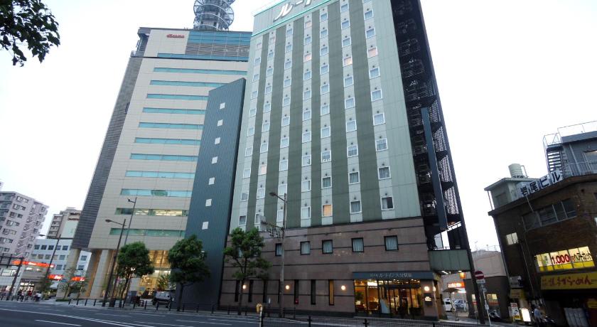 a tall building with a clock on the side of it, Hotel Route-Inn Oitaekimae in Oita