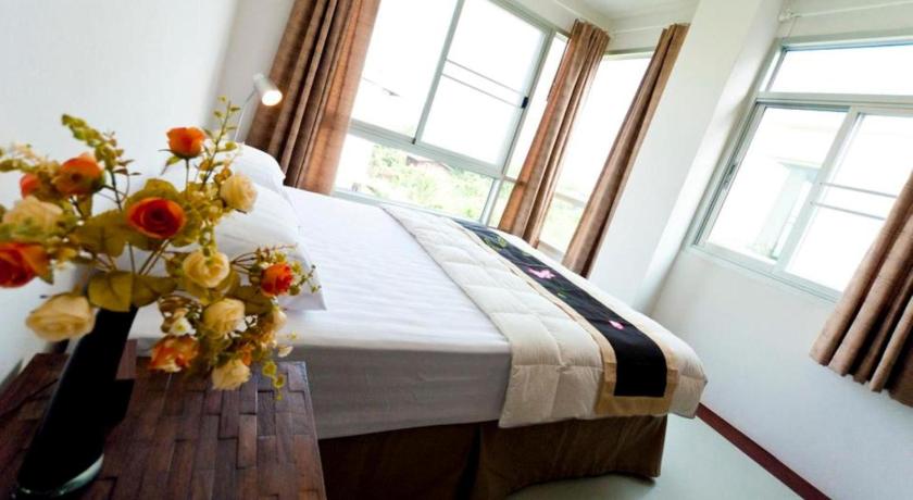 a bed sitting in a room next to a window, The Meet Green Apartment in Bangkok