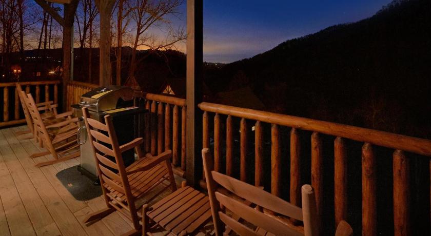 a wooden bench sitting on top of a wooden deck, Otter Springs Pool Cabin in Pigeon Forge (TN)