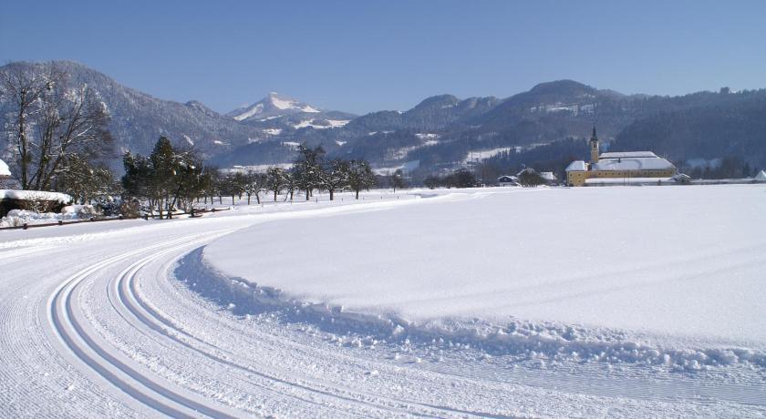 a snow covered field with a snow covered ski slope, Alpenhof Landhotel-Restaurant in Oberaudorf