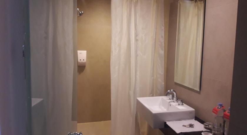 a bathroom with a shower, sink, and mirror, Amaris Hotel Ambon in Ambon