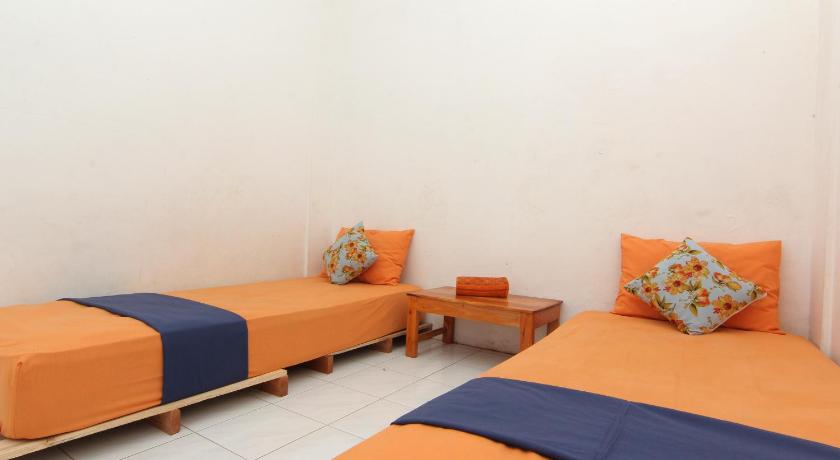 two beds in a hotel room with blue walls, Arjuna 31 Homestay in Yogyakarta
