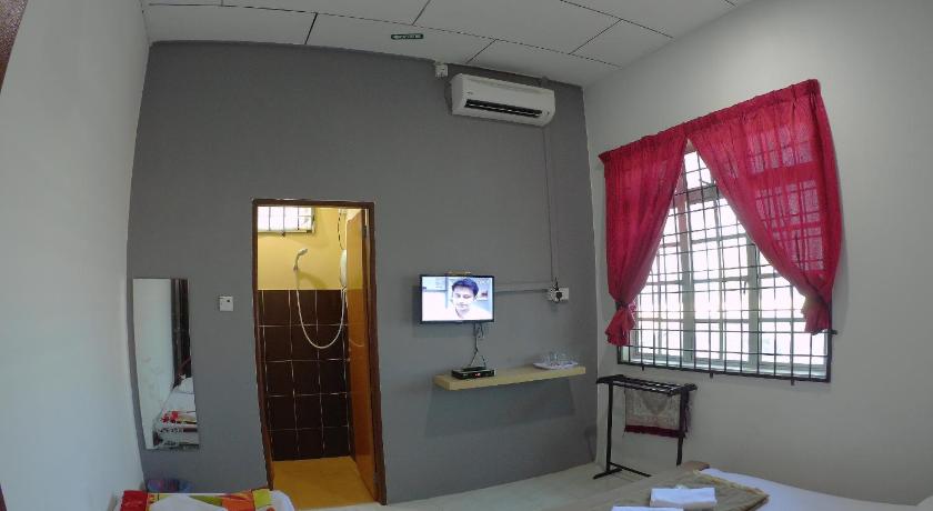 a room with a bed and a television, Semarak Beach Inn Dungun in Dungun