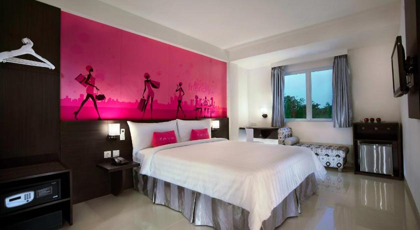 a hotel room with a large bed and a large window, Favehotel Kelapa Gading in Jakarta