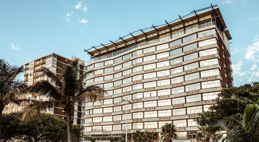 a large building with a large clock on it, Belaire Suites Hotel in Durban