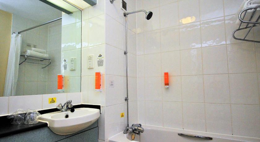 a bathroom with a sink, mirror, and shower stall, Days Inn by Wyndham Hamilton in Hamilton
