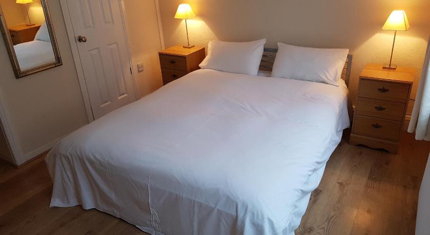 a white bed with a white comforter and pillows, Boscombe Reef Hotel in Bournemouth