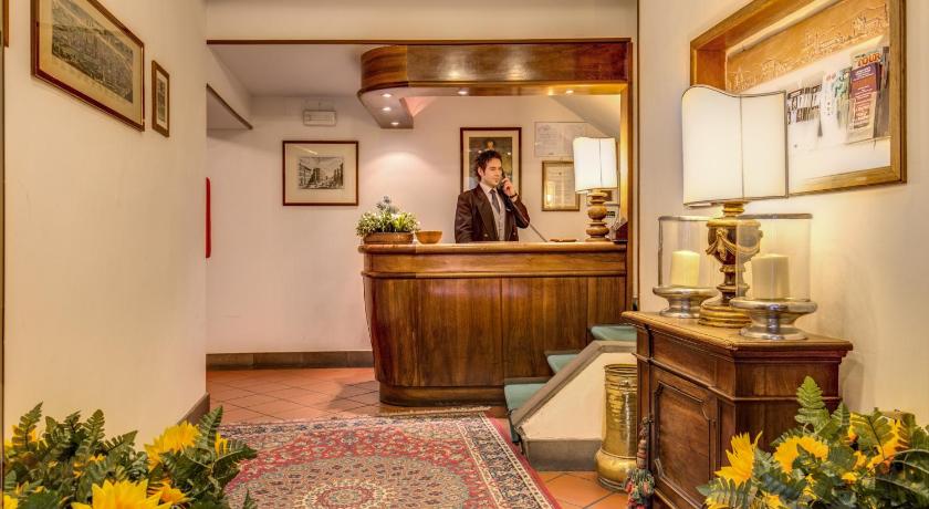 a man standing in front of a counter in a room, Hotel Rex in Florence