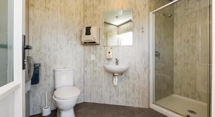 a bathroom with a toilet a sink and a shower, Foxton Beach Holiday Park in Foxton Beach