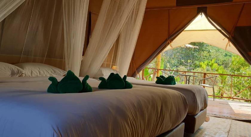 a bed room with a large bed and a large window, Anurak Community Lodge (SHA Extra Plus) in Surat Thani