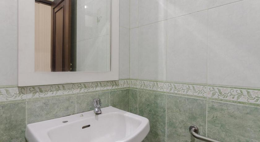 a white sink sitting under a mirror in a bathroom, RedDoorz Syariah @ Cipanas in Puncak