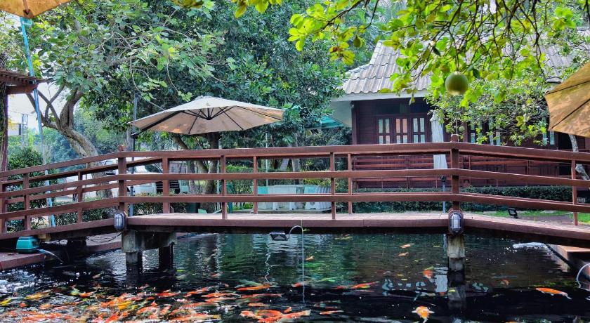 a wooden dock with a wooden fence and a bird house, Baan Kornnara Resort in Amphawa (Samut Songkhram)