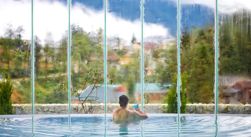 a man sitting in a pool with a surfboard, Silk Path Grand Resort & Spa Sapa in Sapa