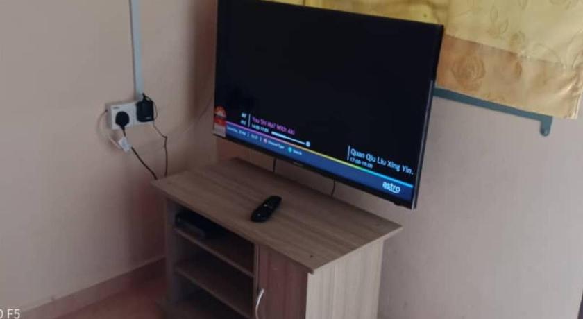 a flat screen tv sitting on top of a wooden stand, Didi Tanah Merah Homestay in Tanah Merah