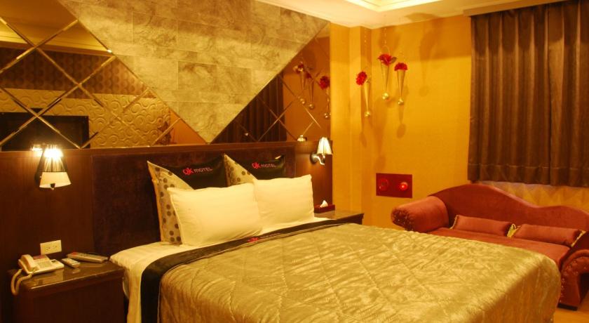 a hotel room with a bed, dresser and a lamp, QK Motel in Taoyuan