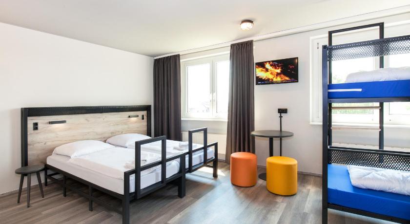 a bedroom with a bed, chair and a television, a&o Berlin Hauptbahnhof in Berlin
