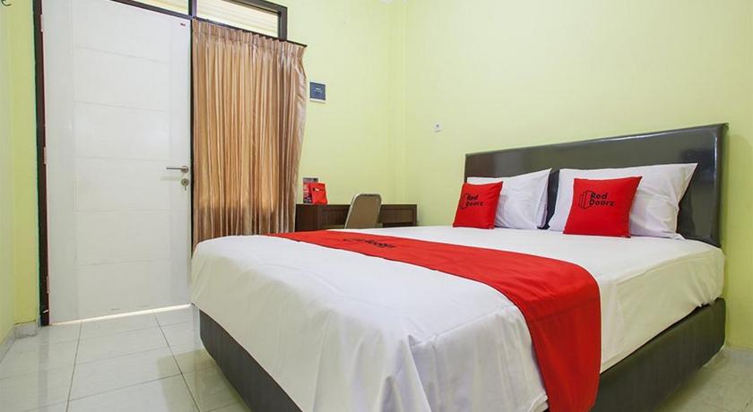 a bedroom with a large bed and a large window, RedDoorz near Petra University 2 in Surabaya