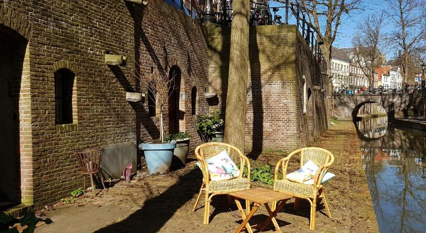 a wooden bench sitting in front of a stone wall, Large Historical Apartment & Canal Terrace in Utrecht