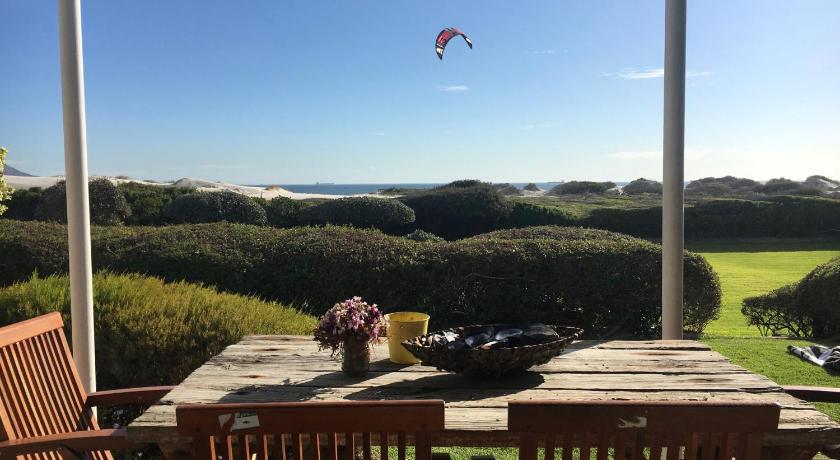 a kite is flying over a picnic table, Dolphin Beach Hotel in Cape Town