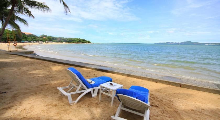 a beach with chairs and umbrellas on the beach, Royal Wing Suites & Spa (SHA Plus+) in Pattaya