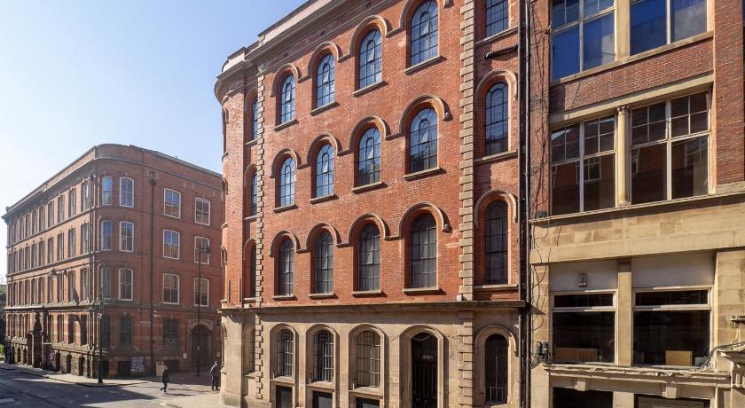 a large brick building with a clock on the side of it, Apartment 16 Broadway House in Nottingham