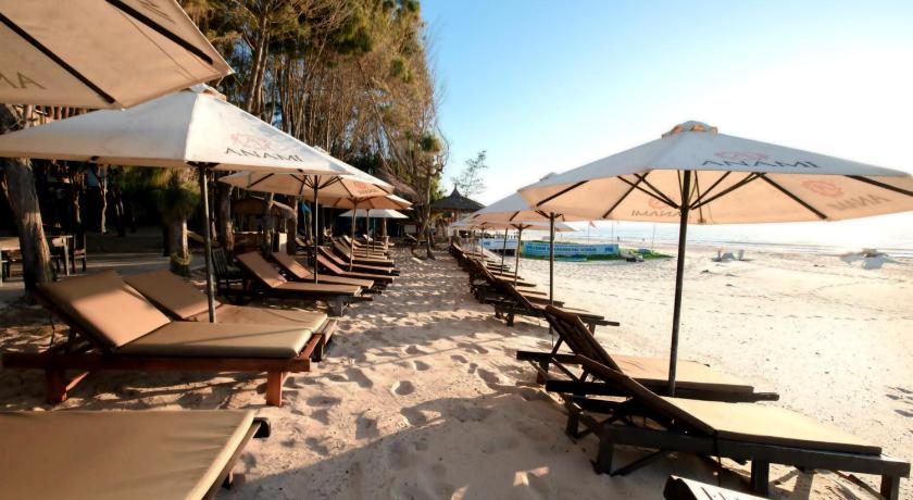 a row of beach chairs and umbrellas on a beach, Anami Muine Beach Resort And Spa in Phan Thiet