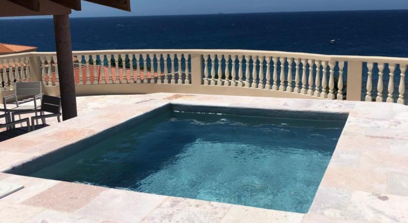 a patio area with a pool and a balcony, The Meridian at Lighthouse Point in Roatan Island