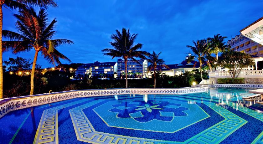 a swimming pool with a blue sky and palm trees, Farglory Hotel in Hualien