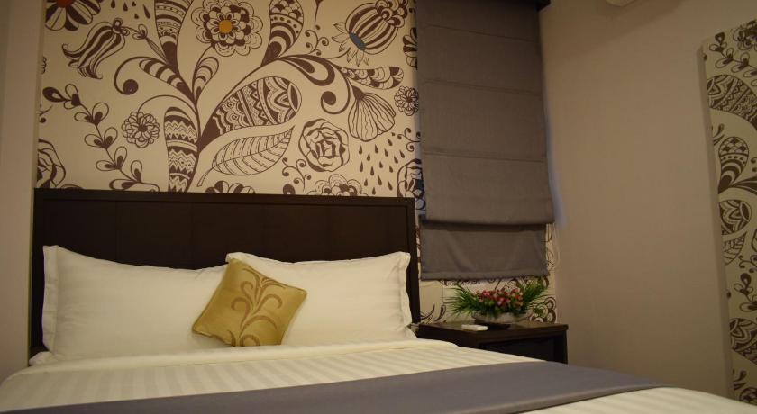 a bed with a white comforter and pillows, MM hotel @ Sunway in Kuala Lumpur