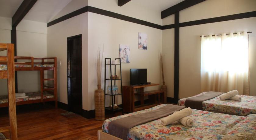 a bedroom with two beds and a television, Calape Forest Resort in Bohol