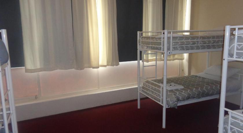 a room with two beds and two windows, Adelaide Backpackers and Travellers Inn in Adelaide