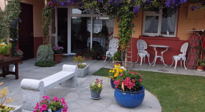 a garden filled with flowers and a bench, Villa St.John B&B in Athlone