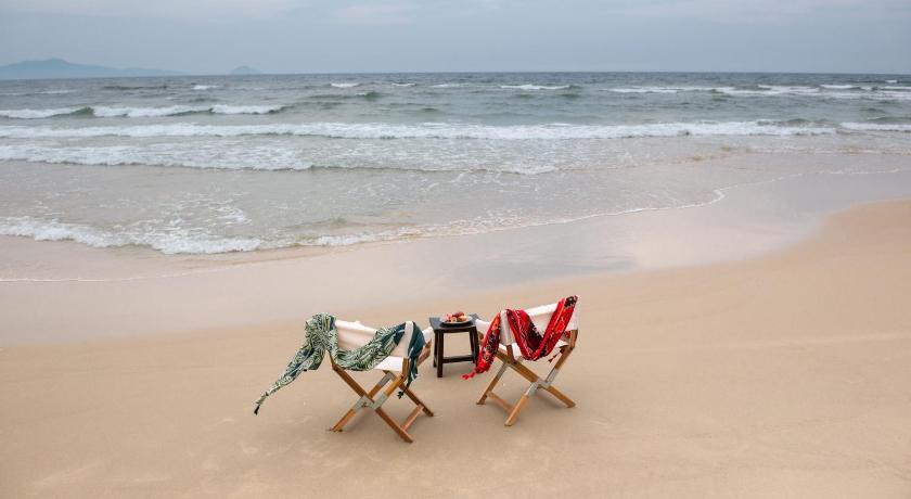 a dog sitting on a chair at the beach, AnnaBo Nam Hoi An Beach House in Hoi An