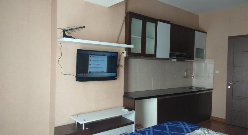a room with a television and a bed in it, Hotel Easton Park by Edutel in Bandung