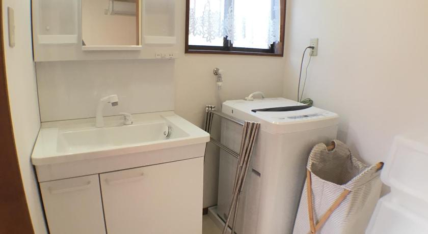 a white toilet sitting next to a sink in a bathroom, machiyado Kuwanajuku Kawaguchi-cho 8 in Yokkaichi