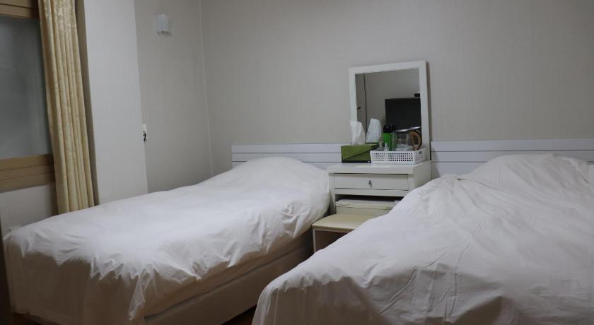 a hotel room with two beds and a mirror, Orasung Motel in Jeju
