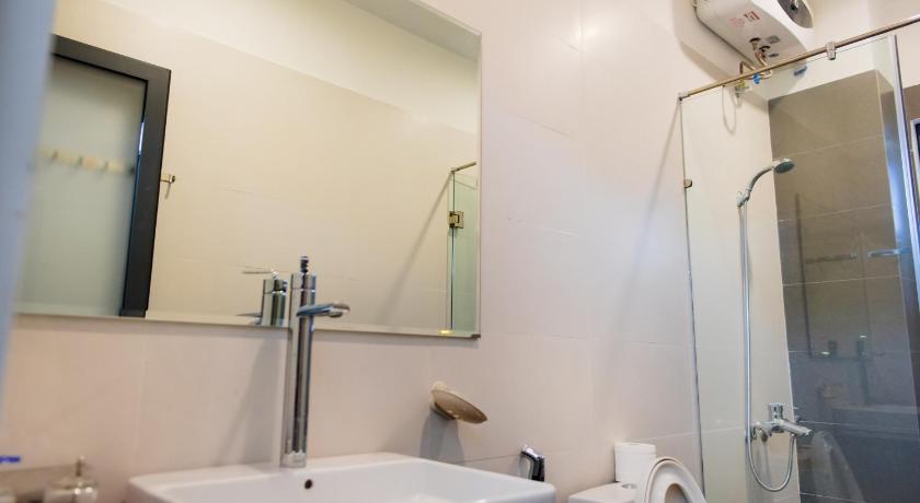 a bathroom with a shower, sink, and mirror, Lama Homestay in Hue