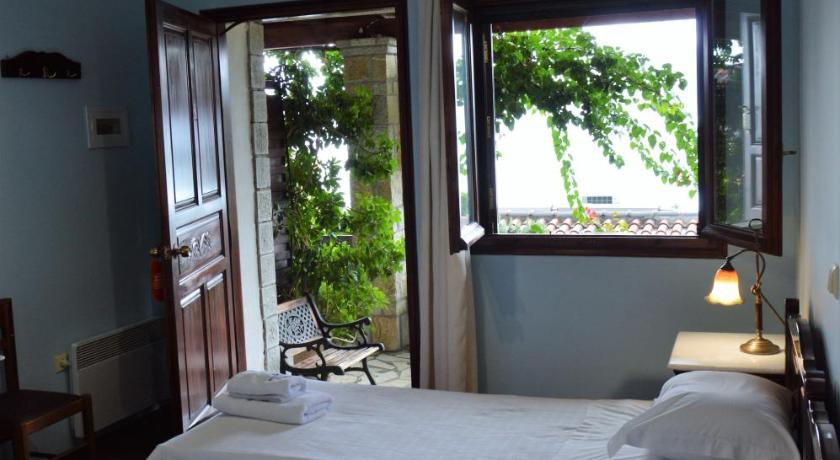 a room with a bed, a lamp, and a window, Ilion Hotel in Nafpaktos