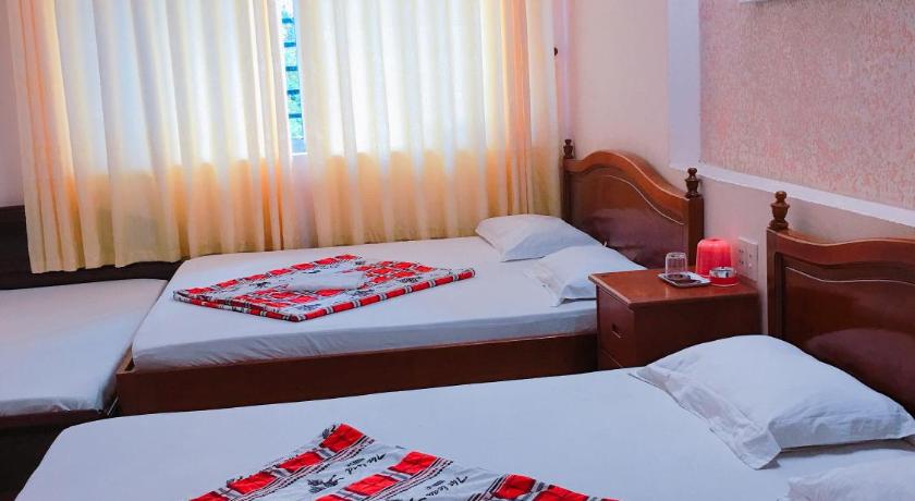 a hotel room with two beds and a window, Quang Diep Motel in Vũng Tàu