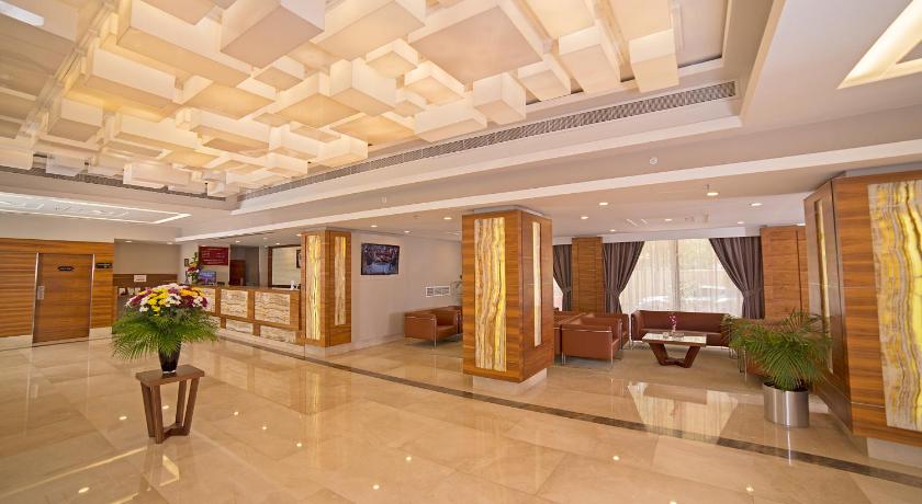 a large room filled with furniture and a large window, Ramada by Wyndham Bahrain in Manama
