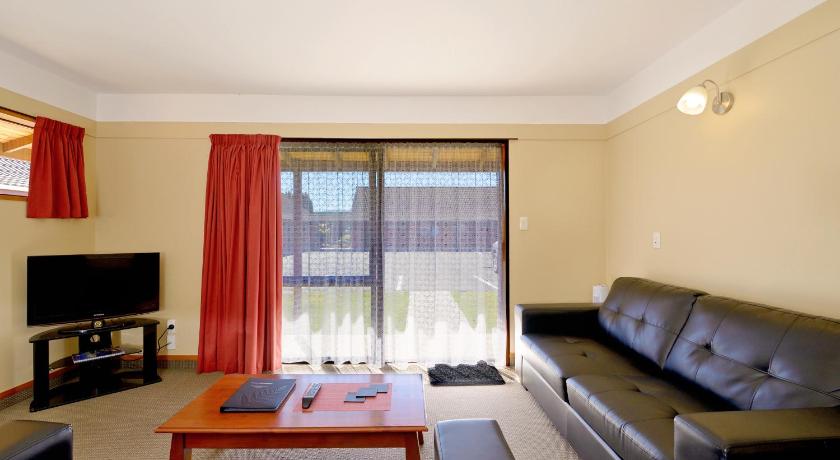 a living room filled with furniture and a tv, Mosgiel Regency Motel in Dunedin