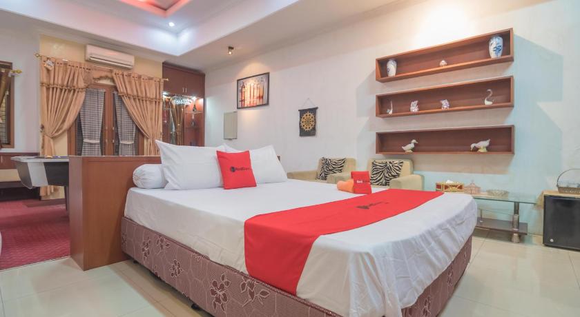 a hotel room with a bed and a dresser, RedDoorz Syariah near Margahayu Raya in Bandung