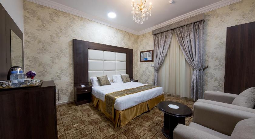 a hotel room with a large bed and a large mirror, أجنحة شاطئ الياسمين - Jasmine Beach Hotel Suites in Yanbu