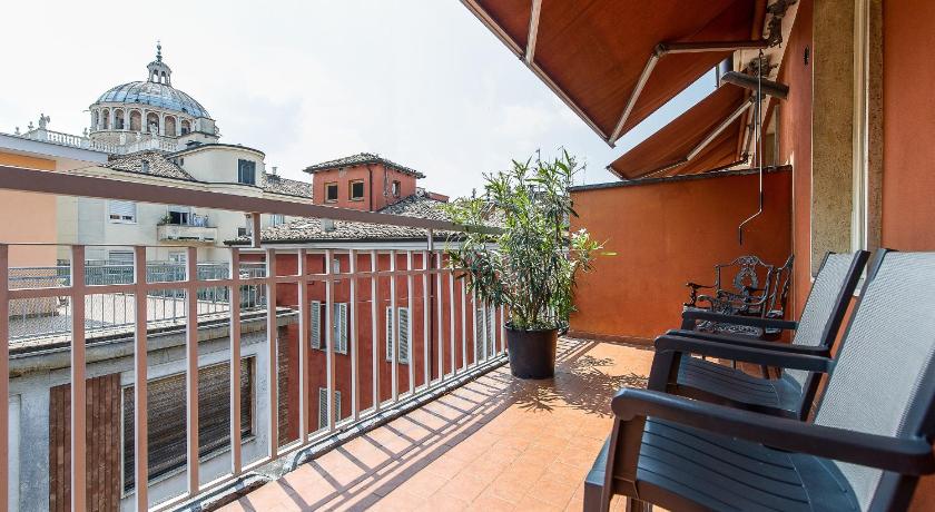 a patio area with chairs, tables, and a balcony, Hotel Torino in Parma