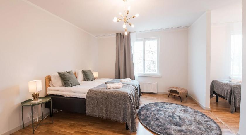 a bedroom with a bed, a chair, and a lamp, Forenom Serviced Apartments Helsinki Toolo in Helsinki