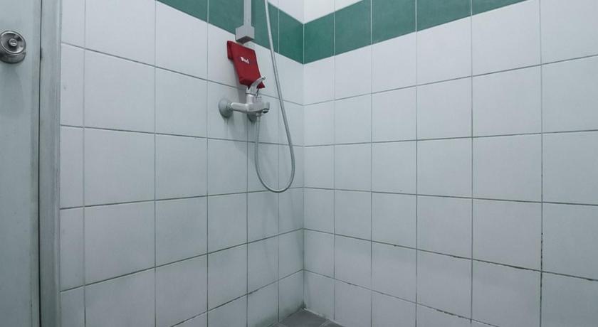 a bathroom with a shower, a toilet, and a tiled floor, RedDoorz @ Buah Batu 3 in Bandung