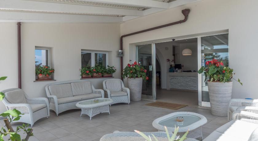 a living room filled with furniture and a patio, Hotel Cala Reale in Stintino