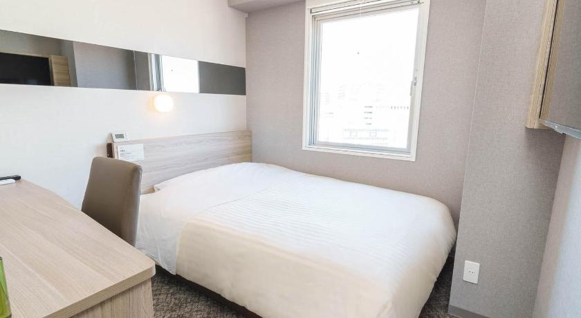 a bedroom with a white bed and white walls, Super Hotel Shonan Fujisawaeki Minamiguchi in Kamakura