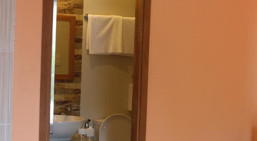 a bathroom with a toilet, sink and mirror, Eurotel Boracay in Boracay Island