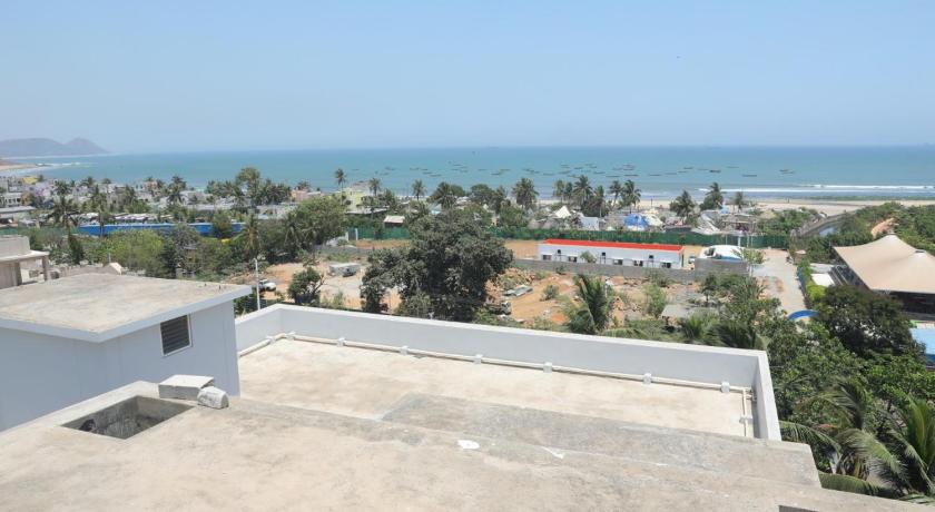 a beach with a beach house and a large building, Brindavan Suites in Visakhapatnam